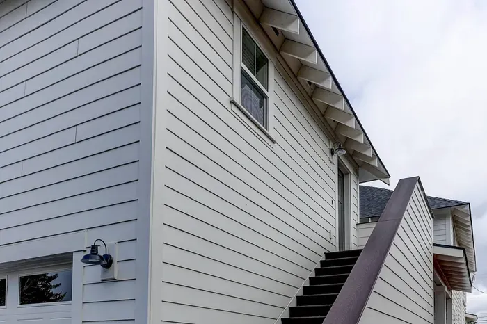 Private upstairs entry with modern siding and bright exterior lighting