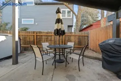 Private fenced patio with outdoor dining, umbrella, and grill