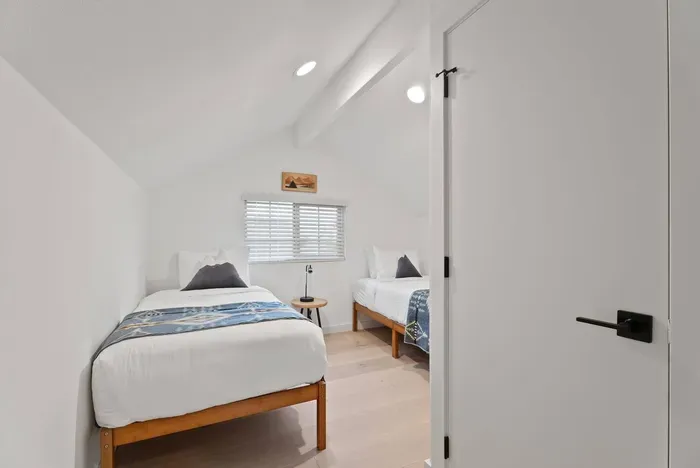 Bright twin bedroom with vaulted ceiling and clean, modern style