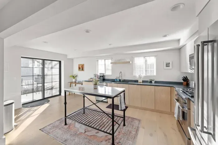 Bright modern kitchen with island, stainless appliances, and patio access