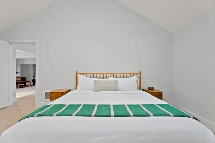Bright vaulted bedroom with crisp linens and warm modern touches