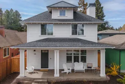 Charming two-story home with a spacious covered porch and inviting seating