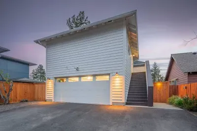 Modern private entry with garage, fenced yard, and warm evening curb appeal