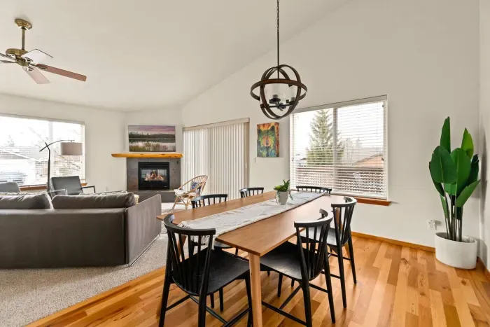 Bright open living space with fireplace, vaulted ceilings, and dining for 6
