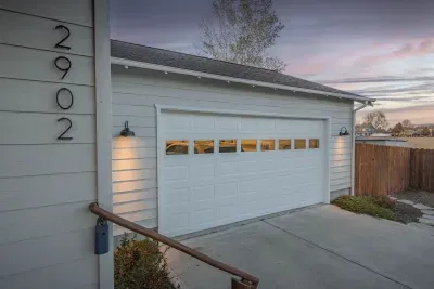 Private driveway and spacious two-car garage with welcoming evening curb appeal