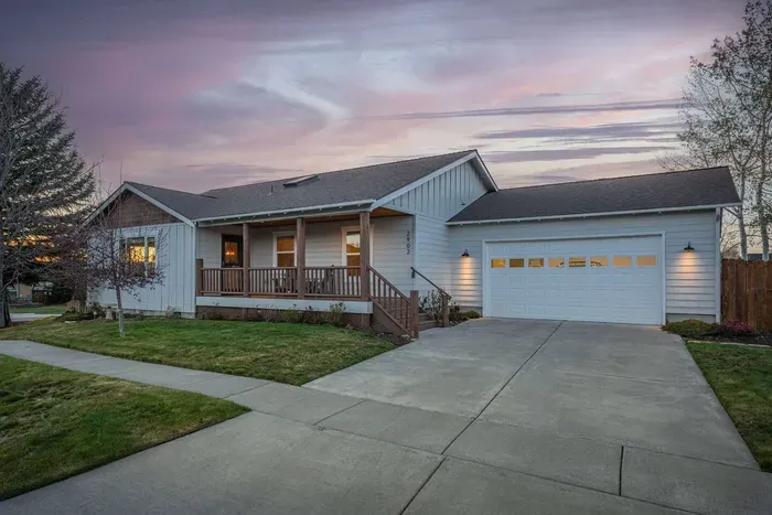 Inviting single-level home with porch, garage, and sunset curb appeal