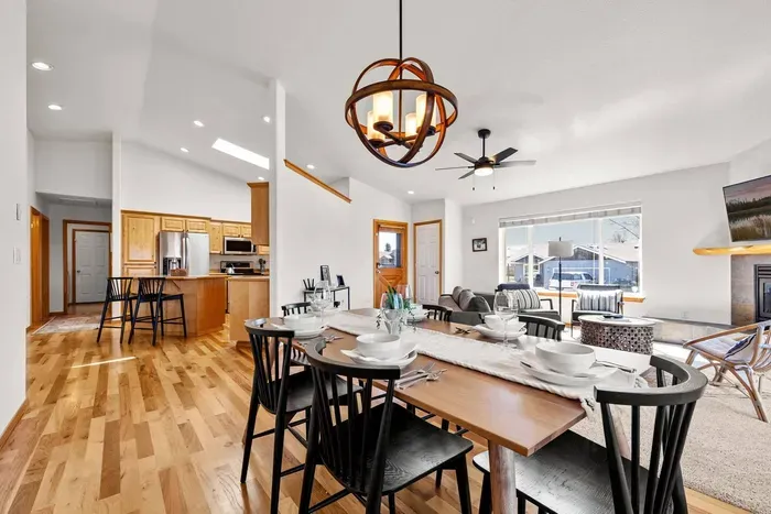 Bright open-concept living, dining, and kitchen with fireplace seating