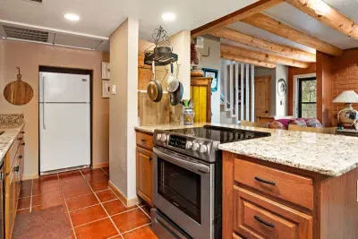 A full vista of the ground floor living space with a kitchen, half bath, living space, dining room and beautiful kiva.