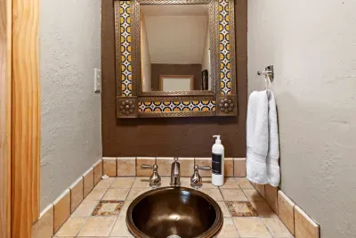 The half bath under the stairs is renovated with a southwestern flare.