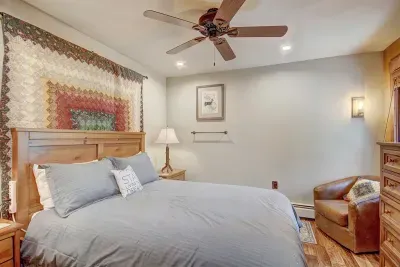 Perfect place to slip away to get some work done- Queen bedroom #1 with comfy seating, Smart TV and plenty of storage.