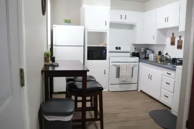 Full kitchen with electric range, microwave, full-size refrigerator, and dining table for two.