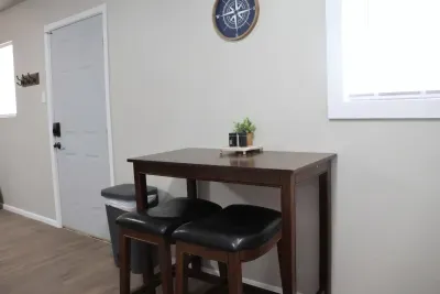 Dining table with seating for two near the entry with coat hooks.