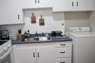 Full kitchen with electric range, double sink, and cookware for extended stays.