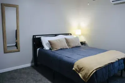 Clean bedroom with bedside lighting and full-length mirror for getting ready.