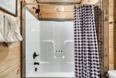 Lower level large bathroom with bathtub and single sink - attached to both bunkroom and movie/gameroom