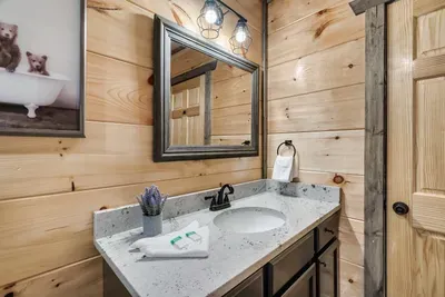 Lower level large bathroom with bathtub and single sink - attached to both bunkroom and movie/gameroom