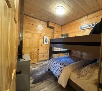 Lower level bunkroom with 2 queen beds, next to movie/gameroom and walkout hot tub - attached large bathroom with bathtub and single sink
