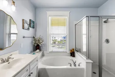 Thoughtfully designed family-friendly bathroom featuring a full tub, separate shower, toilet closet, clothes closet, and plenty of space.