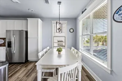 Enjoy time together at this spacious table with plenty with sunny views and coastal charm.