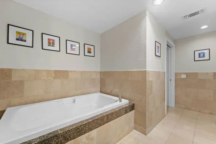 Luxurious bathroom with a deep soaking tub and modern tile design.