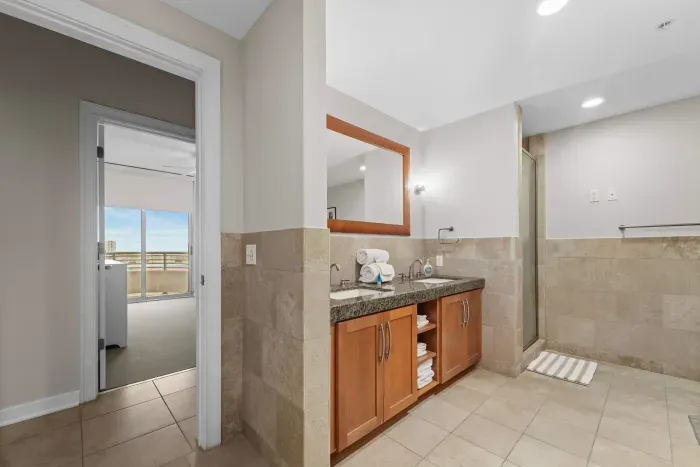 Bright and airy bathroom featuring a large walk-in shower and double vanity.