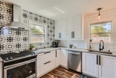 Step into the remodeled kitchen, featuring elegant cream-colored tiles with a unique catcher's design. The modern upgrades and stylish details create a warm and inviting space, perfect for cooking and entertaining.