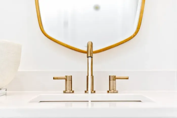 Elegant bathroom vanity with a sleek gold faucet and modern design.