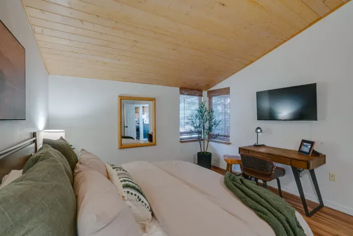 Elegant master bedroom featuring cozy textures and warm cabin-style architecture.