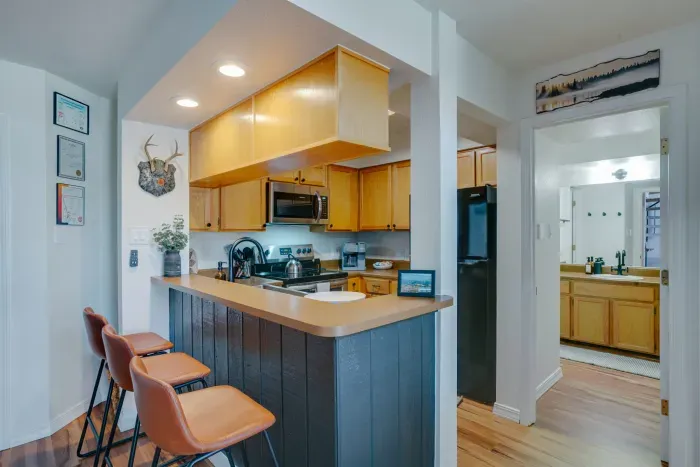 A fully equipped kitchen with stainless appliances, warm cabinetry, and everything needed for cooking in the mountains.