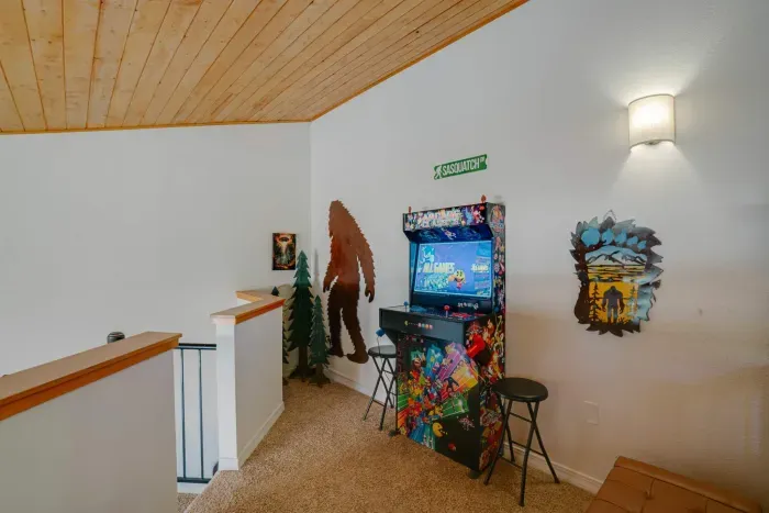 A playful guest retreat featuring cozy lighting and classic arcade entertainment.