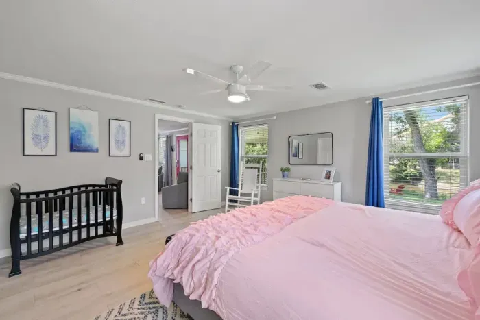 Relax in the spacious primary bedroom, thoughtfully equipped with a mini crib for your little one. This cozy setup ensures a restful night for both parents and baby, creating a comfortable and peaceful retreat for the whole family.