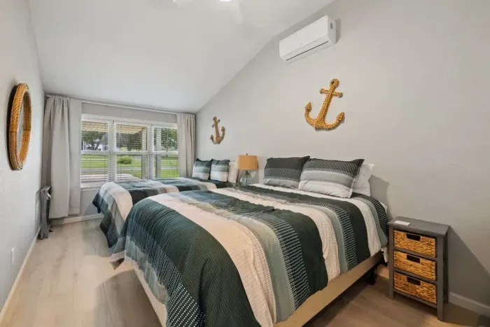 Spacious third bedroom featuring two queen beds, ideal for accommodating multiple guests comfortably. This setup is perfect for families or friends sharing a room, offering ample sleeping space without compromising on comfort.