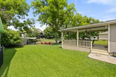 Spacious backyard with a lush lawn, perfect for outdoor games, relaxation, and barbecues.