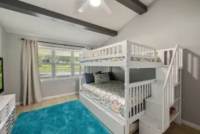 The fourth bedroom offers plenty of space for everyone, featuring a full-size bunk bed with a convenient trundle underneath. This versatile setup maximizes sleeping accommodations, making it ideal for families or groups. Perfect cozy atmosphere.