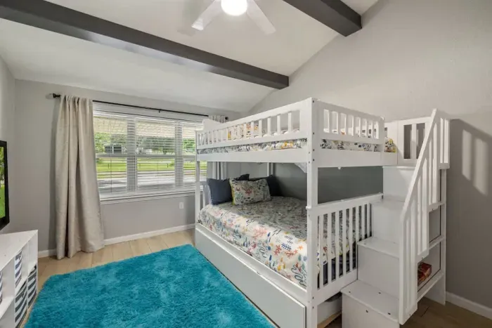 The fourth bedroom offers plenty of space for everyone, featuring a full-size bunk bed with a convenient trundle underneath. This versatile setup maximizes sleeping accommodations, making it ideal for families or groups. Perfect cozy atmosphere.