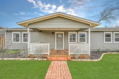 Inviting front entry with lush greenery and a well-maintained lawn.