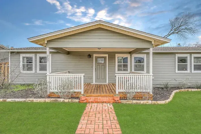 Inviting front entry with lush greenery and a well-maintained lawn.