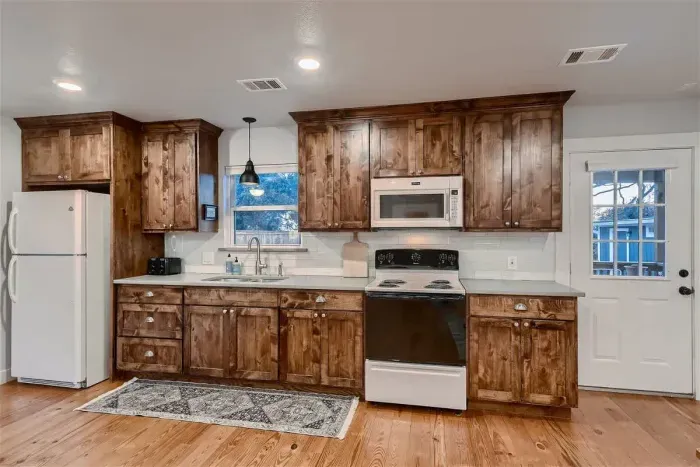 Cook with ease in a fully equipped kitchen featuring rustic wood cabinetry, modern appliances, and plenty of counter space.