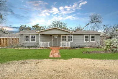 Inviting front entry with lush greenery and a well-maintained lawn.