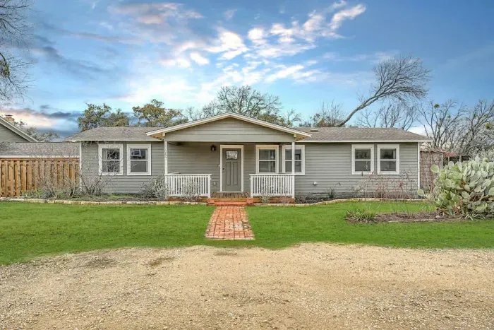 Inviting front entry with lush greenery and a well-maintained lawn.