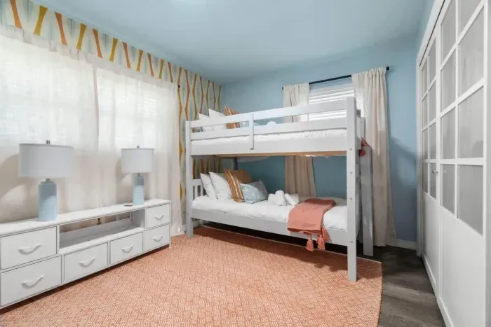 Family-friendly bedroom with two bunk beds and fun, whimsical decor.