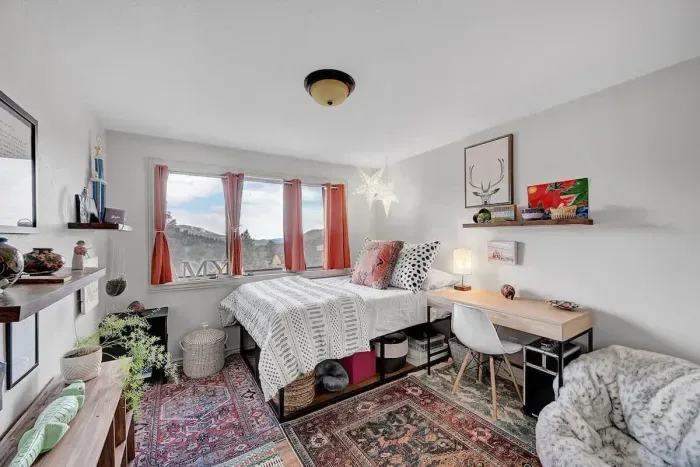 Bright and charming bedroom with mountain views, cozy decor, and a workspace for remote travelers.