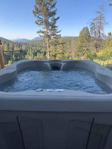 Soak in the private hot tub with stunning mountain views, the perfect way to relax after a day of exploring.