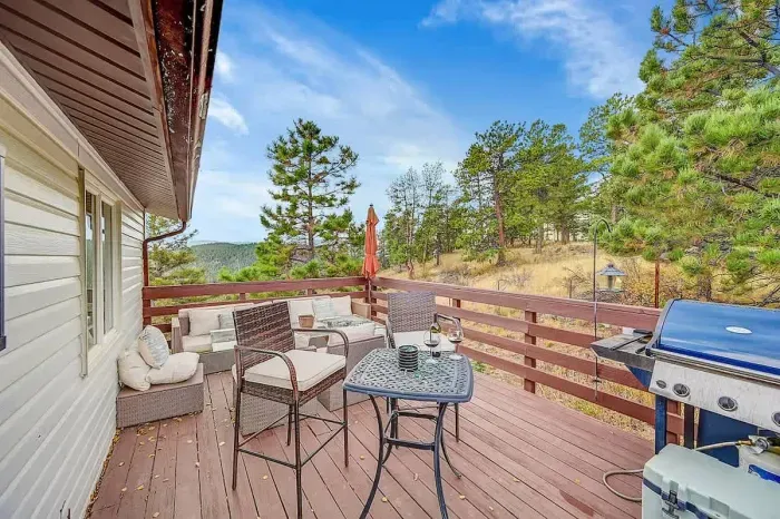 Outdoor deck with lounge seating, BBQ grill, and incredible mountain and forest views, perfect for coffee or stargazing.
