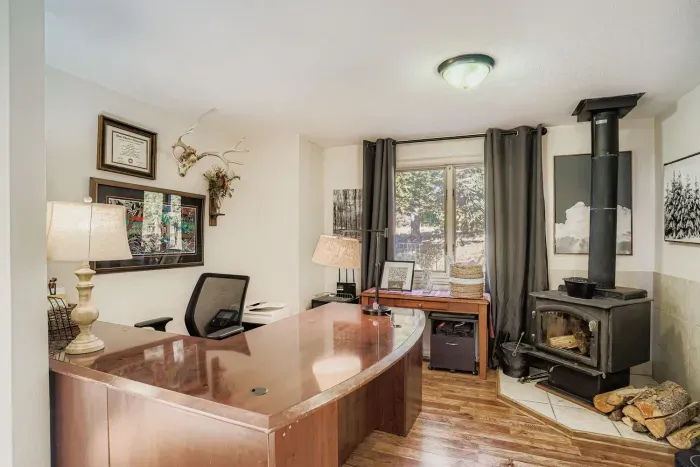Cozy workspace with wood desk, fireplace, and natural light.