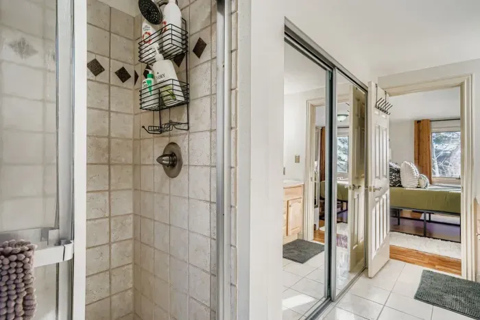 Elegant primary bathroom with walk-in shower and dual vanity.