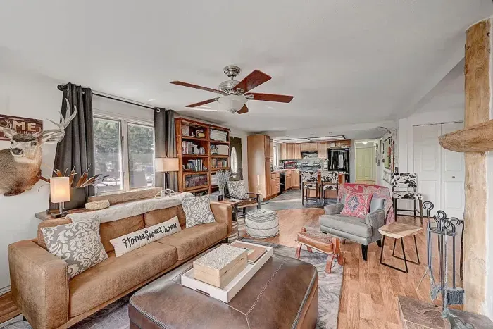 Warm, inviting living space with a fireplace and large windows framing the forest views.
