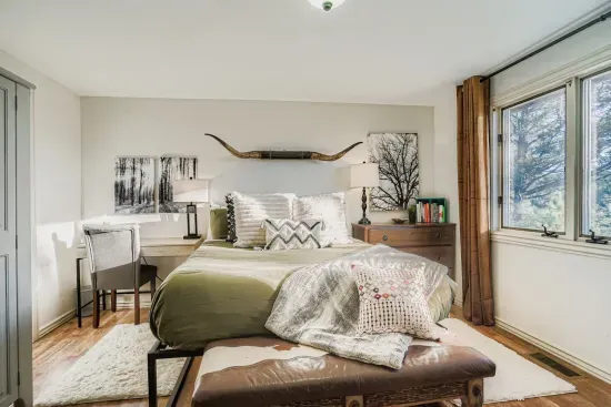 Bright master bedroom with cozy touches and plenty of natural light.