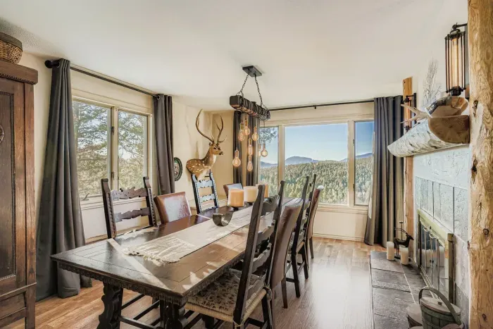 Elegant dining room with panoramic forest and mountain views.
