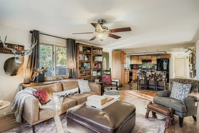 Spacious living area with plush seating and large windows overlooking nature.